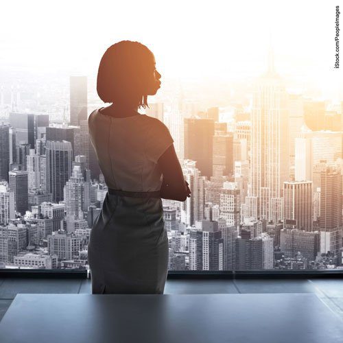 rearview shot of a woman executive staring out of a boardroom highrise window